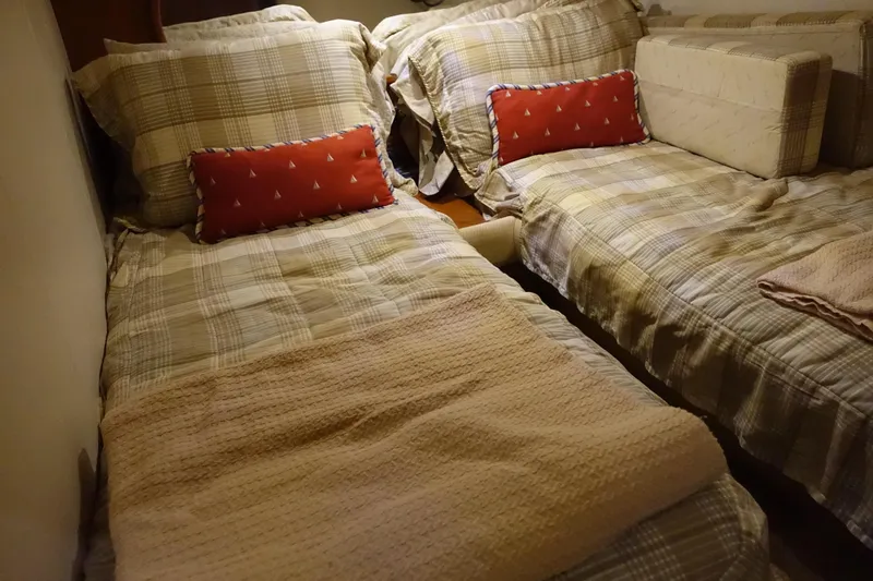 Slide: The Image of Cozy twin beds in 2007 Chris-Craft Roamer 40 cabin, featuring plaid bedding and decorative pillows. - 24