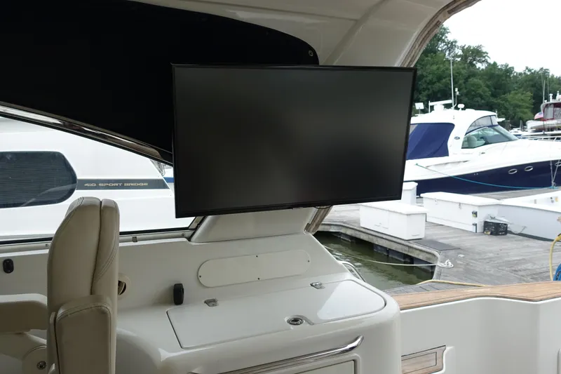 Slide: The Image of 2007 Chris-Craft Roamer 40 yacht interior with mounted TV and dock view. - 9