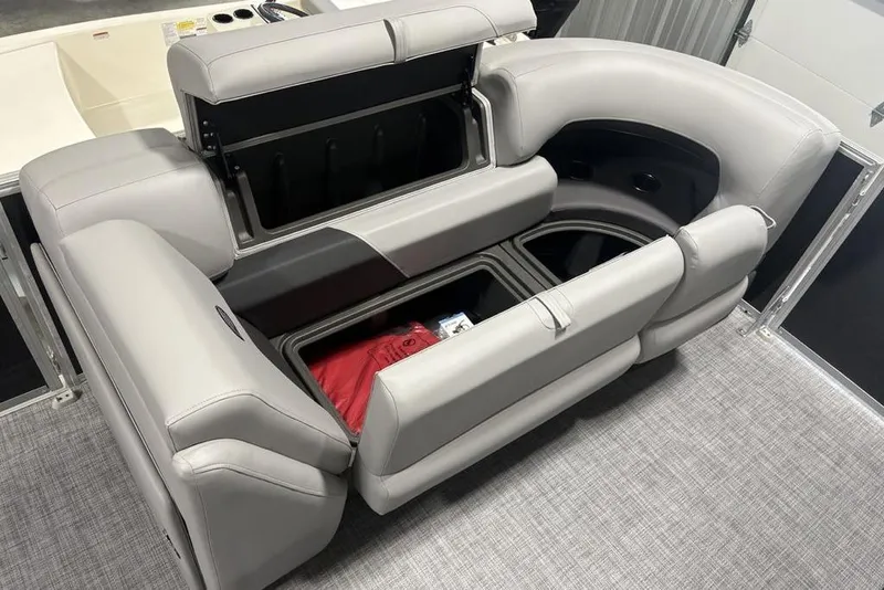 Slide: The Image of 2026 Sun Tracker PARTY BARGE® 22 XP3 with open storage compartments and gray seating. - 12