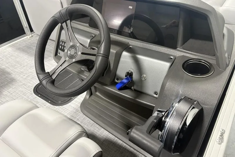 Slide: The Image of 2026 Sun Tracker PARTY BARGE® 22 XP3 steering console with modern controls and cup holder. - 19