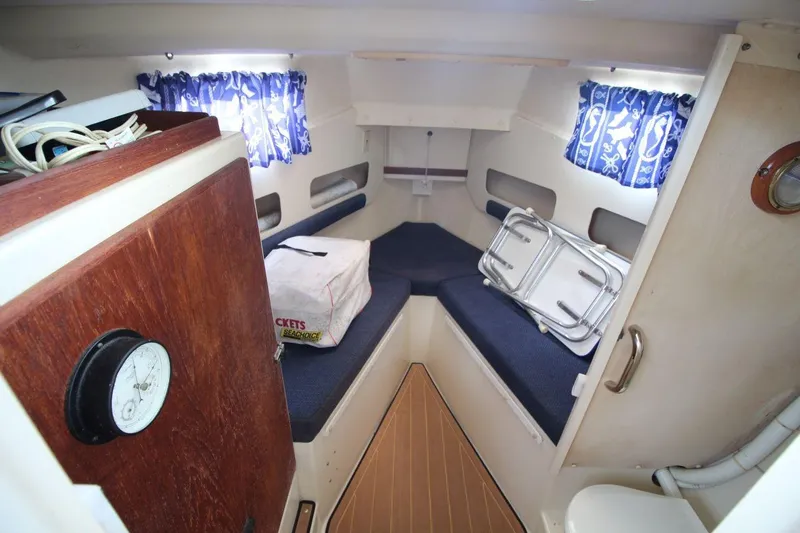 Slide: The Image of 2002 Rosborough RF-246 Sedan Cruiser cabin interior with blue cushions and nautical curtains. - 18