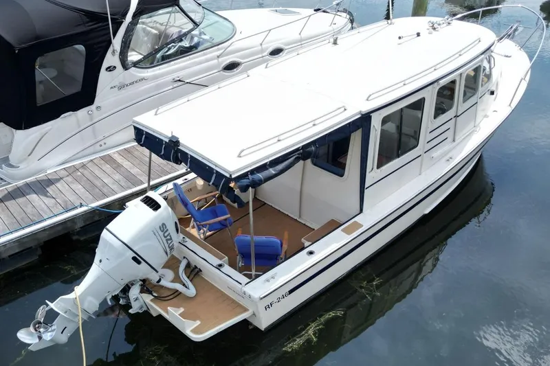 Slide: The Image of 2002 Rosborough RF-246 Sedan Cruiser docked with outboard motor and seating. - 2