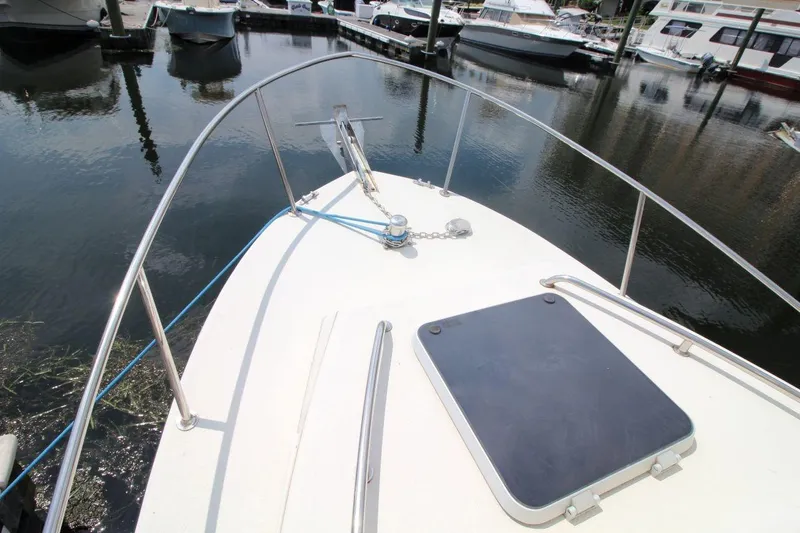 Slide: The Image of 2002 Rosborough RF-246 Sedan Cruiser bow view at marina, featuring anchor and hatch. - 7