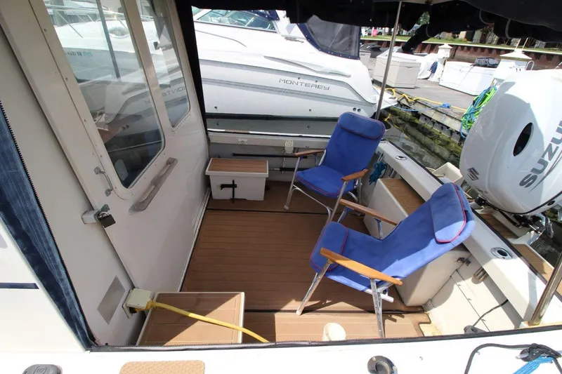 Slide: The Image of 2002 Rosborough RF-246 Sedan Cruiser interior with blue chairs and Suzuki outboard motor. - 9