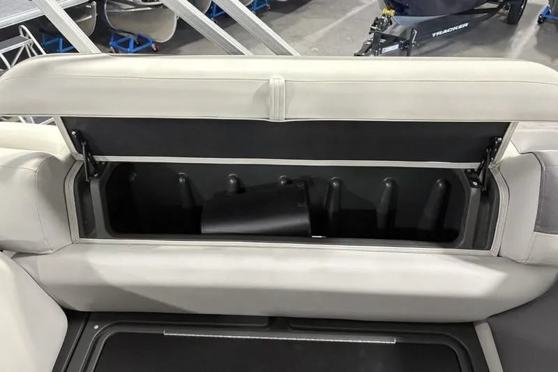 Slide: The Image of 2026 Sun Tracker Fishin' Barge 22 XP3 storage compartment with open seat lid. - 26