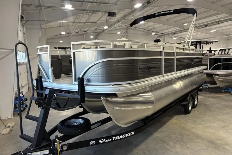 Slide: The Image of 2026 Sun Tracker Fishin' Barge 22 XP3 pontoon boat in a showroom. - 5