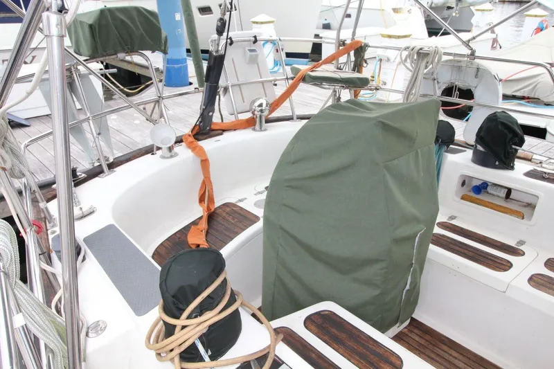 Slide: The Image of Cockpit of 1985 Passport 47 sailboat with covered equipment and wooden accents. - 12
