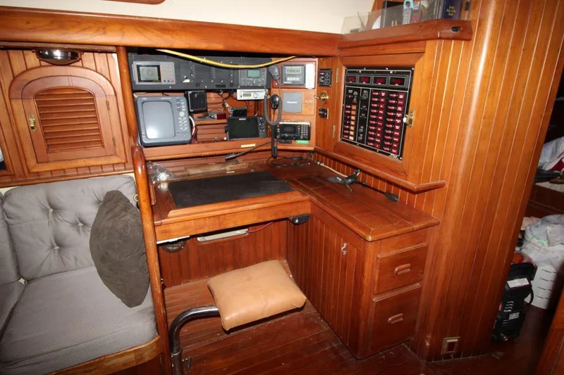 Slide: The Image of Vintage 1985 Passport 47 yacht navigation station with wooden cabinetry and electronic equipment. - 19