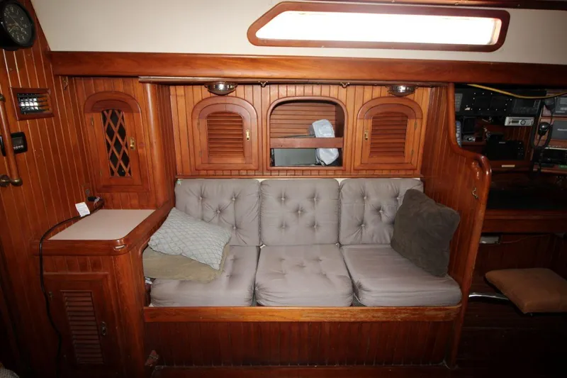 Slide: The Image of Cozy wooden interior of 1985 Passport 47 yacht with cushioned seating and storage cabinets. - 22