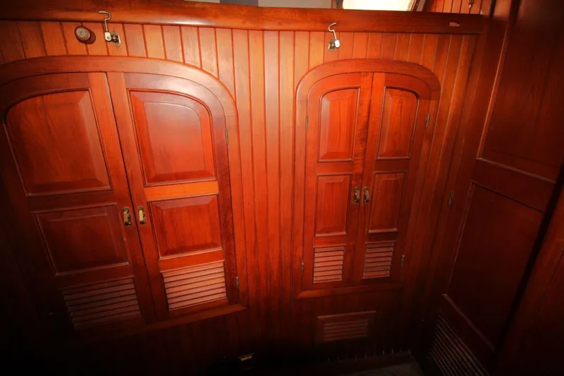 Slide: The Image of Wooden interior of 1985 Passport 47 yacht, featuring elegant cabinetry and warm tones. - 24