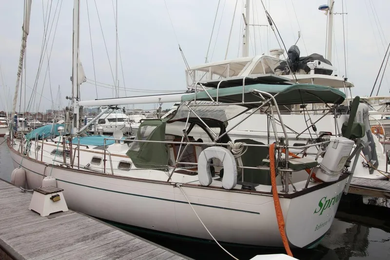 Slide: The Image of Sailboat docked at marina, Passport 47 model, 1985, with green canopy and life preserver. - 4