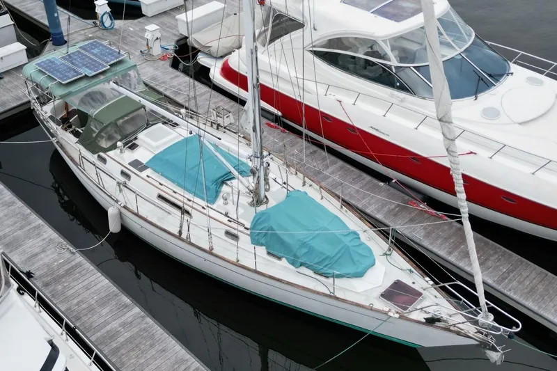 Slide: The Image of Sailboat docked at marina, Passport 47 model, 1985, with solar panels and teal covers. - 6