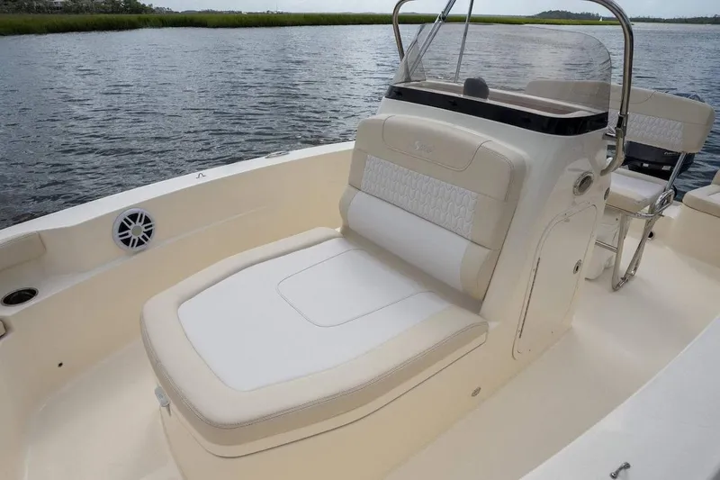 Slide: The Image of 2026 Scout 188 Sportfish boat interior with beige seating on calm water. - 10