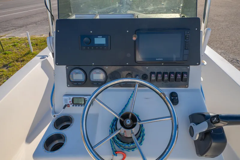 Slide: The Image of Control panel of a 2001 Pathfinder 2400-V boat with steering wheel and navigation instruments. - 17