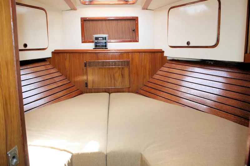 Slide: The Image of 1980 Sea Ray 300 Weekender cabin interior with wood paneling and beige cushions. - 11