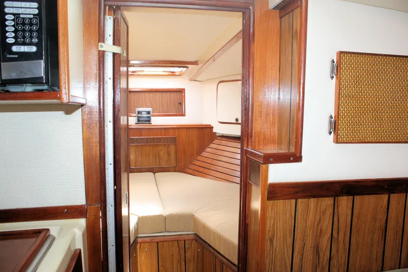 Slide: The Image of Interior of 1980 Sea Ray 300 Weekender boat with wood paneling and cozy sleeping area. - 12