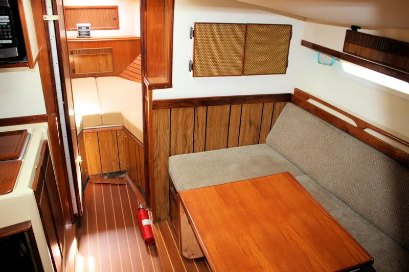 Slide: The Image of Interior of 1980 Sea Ray 300 Weekender, featuring wood paneling and cozy seating area. - 14