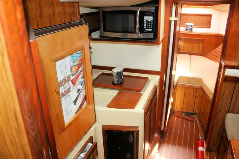 Slide: The Image of 1980 Sea Ray 300 Weekender cabin interior with wood paneling and kitchenette. - 20