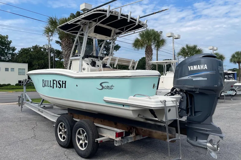 Slide: The Image of 2006 Scout 242 Sportfish boat with Yamaha engine on trailer, parked outdoors. - 2