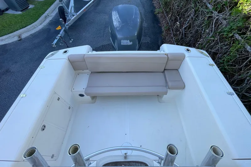 Slide: The Image of 2006 Scout 242 Sportfish boat with cushioned seating and outboard motor, parked on a trailer. - 27