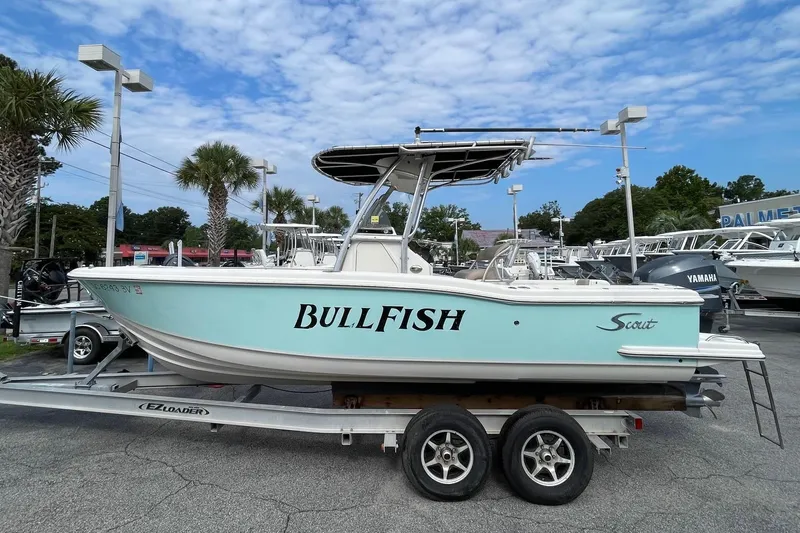 Slide: The Image of 2006 Scout 242 Sportfish boat on trailer, labeled "Bullfish," in a marina setting. - 3