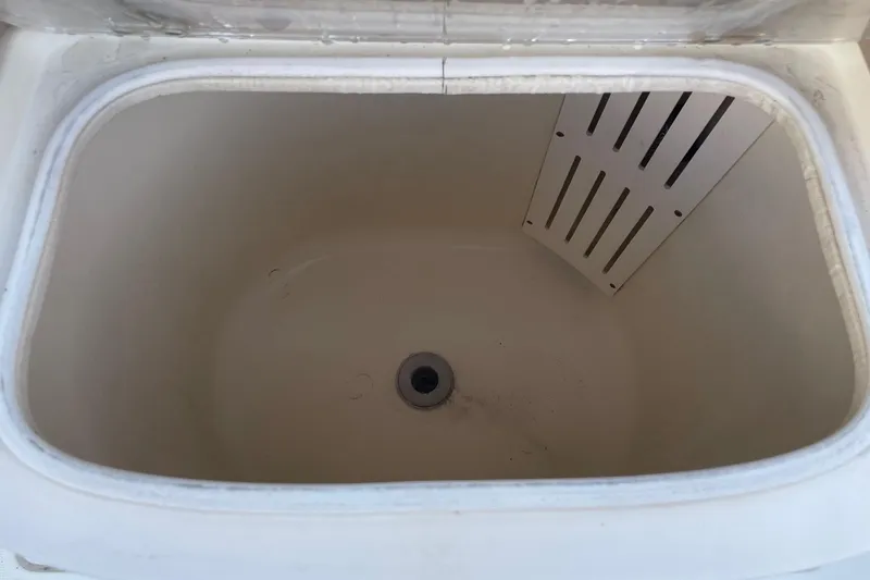 Slide: The Image of Livewell compartment of a 2006 Scout 242 Sportfish boat, featuring a drain and divider. - 30