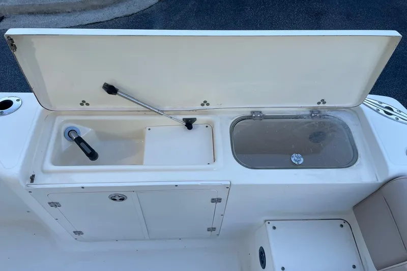 Slide: The Image of 2006 Scout 242 Sportfish boat with open storage compartments and sink. - 32
