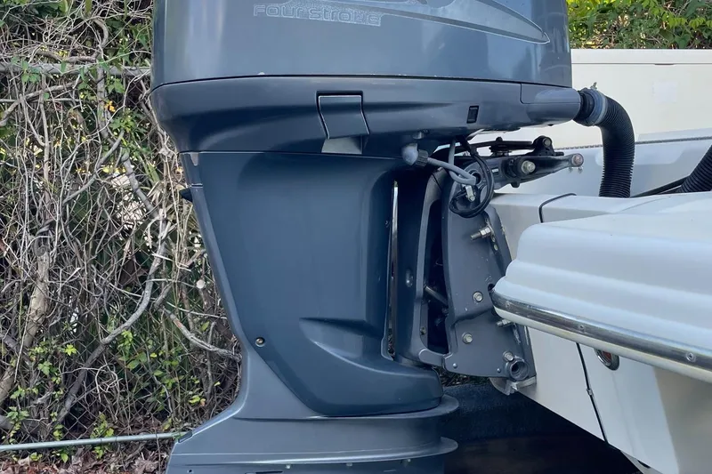 Slide: The Image of Outboard motor of a 2006 Scout 242 Sportfish boat, surrounded by foliage. - 59
