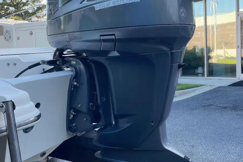 Slide: The Image of Outboard motor on a 2006 Scout 242 Sportfish boat, parked near a building. - 60