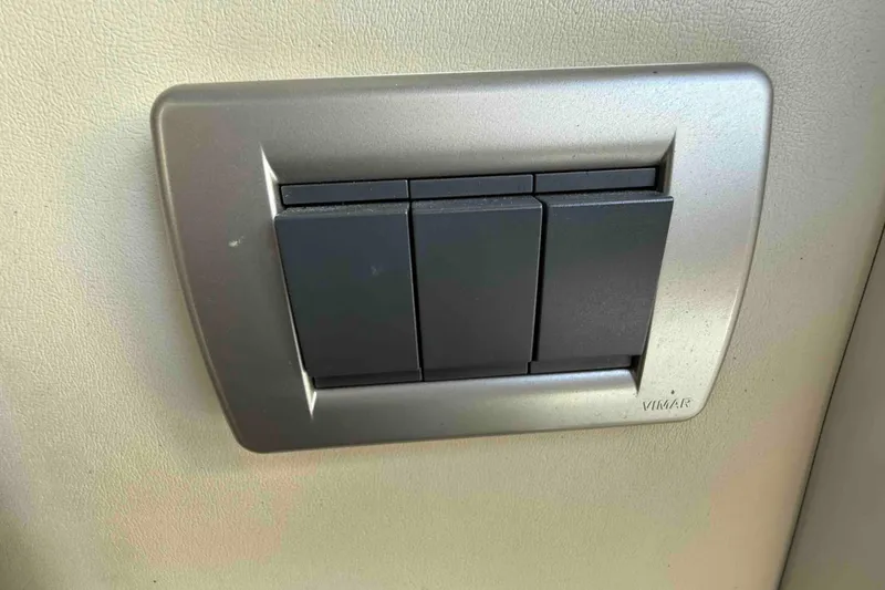 Slide: The Image of Three black switches on a beige wall in a 2007 Formula 27 Performance Cruiser. - 45