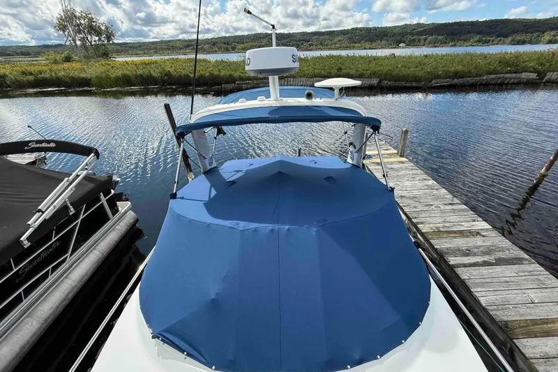 Slide: The Image of 2007 Formula 27 Performance Cruiser docked by a scenic lake under a cloudy sky. - 5