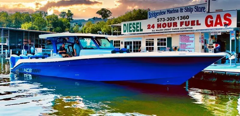 Slide: The Image of 2025 HCB 48 Campeon boat docked at Bridgeview Marina, vibrant blue hull. - 20