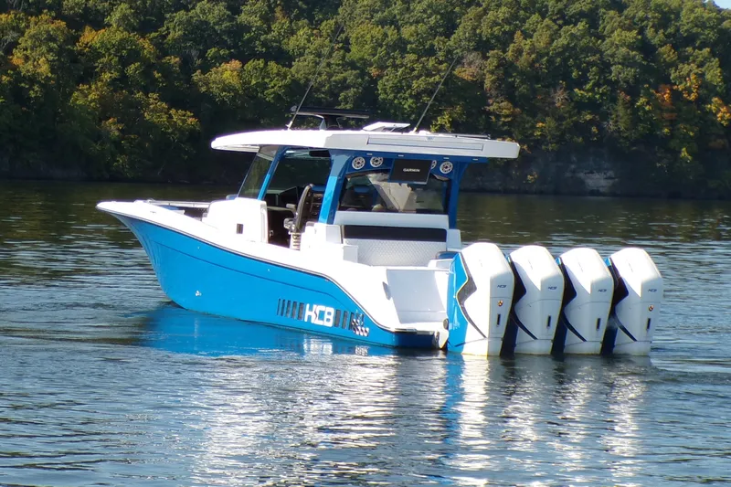 Slide: The Image of 2025 HCB 48FT Campeon boat with four engines on a calm lake. - 3