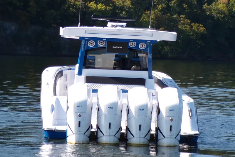 Slide: The Image of 2025 HCB 48FT Campeon boat with four powerful outboard engines on a calm lake. - 4