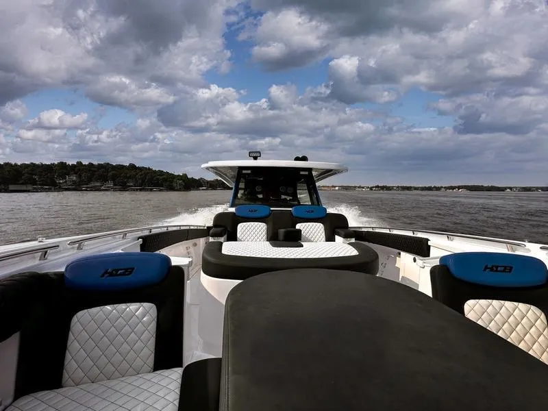 Slide: The Image of 2025 HCB 48 Campeon boat cruising on a lake under cloudy skies. - 7