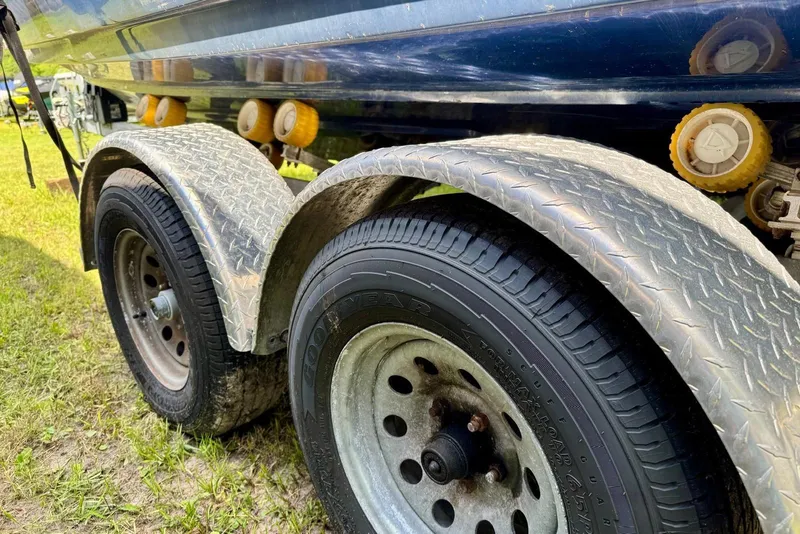 Slide: The Image of Trailer wheels and fender of a 2011 Yamaha Boats SX240 HO on grass. - 13