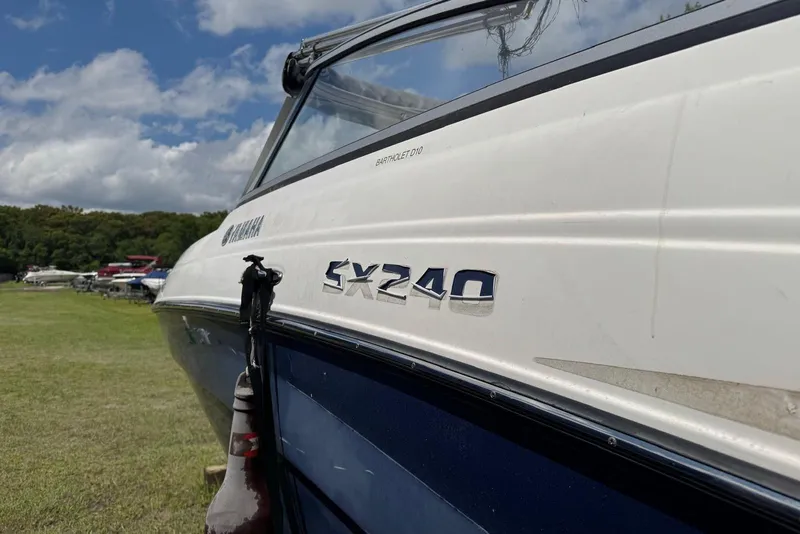 Slide: The Image of 2011 Yamaha Boats SX240 HO on grassy field under blue sky. - 2
