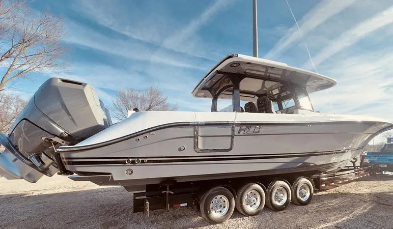 Slide: The Image of 2024 HCB 42 Lujo boat on a trailer with triple outboard engines. - 3