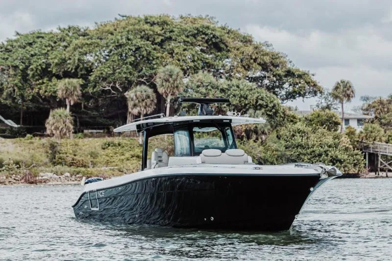 Slide: The Image of 2024 HCB 42 Lujo boat on water near lush greenery. - 6