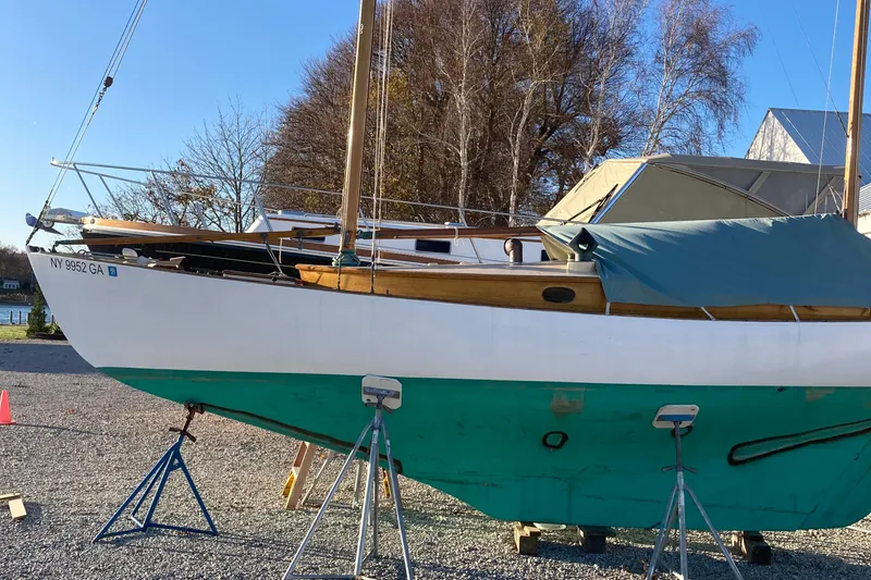 Slide: The Image of 1974 Herreshoff Rozinante sailboat on stands, with green hull and covered deck. - 46
