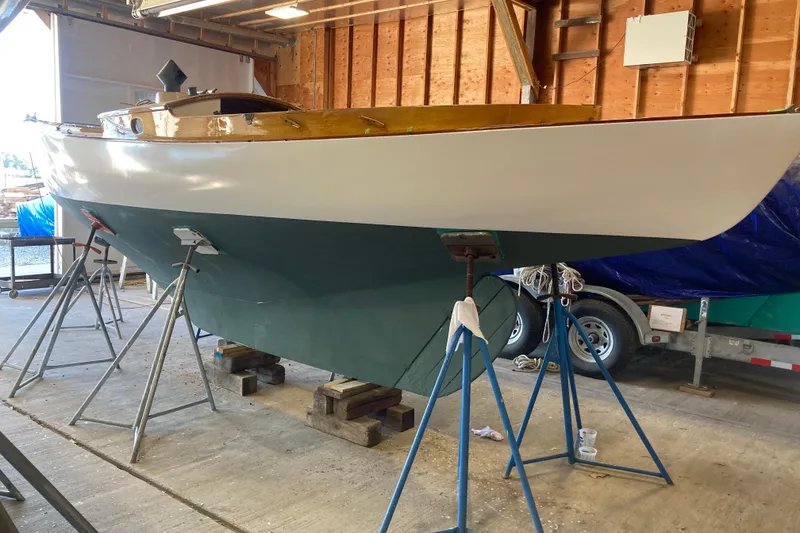 Slide: The Image of 1974 Herreshoff Rozinante sailboat in a workshop, elevated on stands. - 29