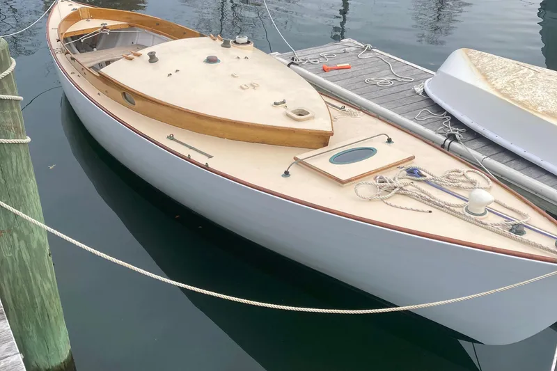 Slide: The Image of 1974 Herreshoff Rozinante sailboat docked, showcasing classic wooden design and sleek lines. - 13