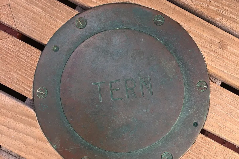 Slide: The Image of Bronze plate with "TERN" engraved, on wooden deck of 1974 Herreshoff Rozinante. - 34