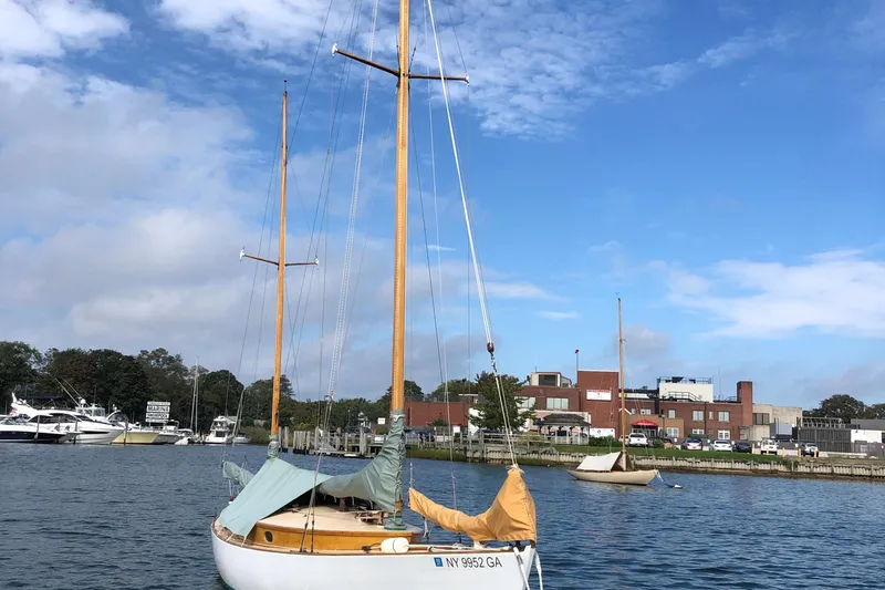 Slide: The Image of 1974 Herreshoff Rozinante sailboat docked at marina under blue sky. - 57