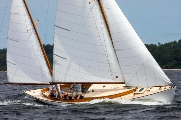 The Image of 1974 Herreshoff Rozinante sailboat gliding on water with full sails, showcasing classic design. - 1