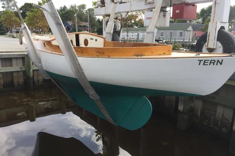 Slide: The Image of 1974 Herreshoff Rozinante sailboat "TERN" suspended above water at a dock. - 20