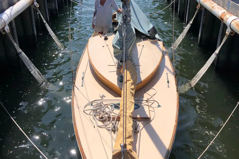 Slide: The Image of 1974 Herreshoff Rozinante sailboat docked, viewed from above, with ropes and sails visible. - 19
