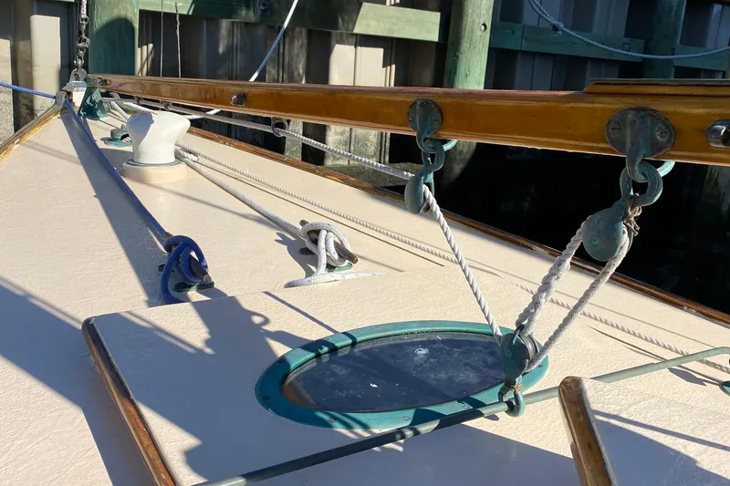 Slide: The Image of Deck of 1974 Herreshoff Rozinante sailboat with ropes and fittings in sunlight. - 31