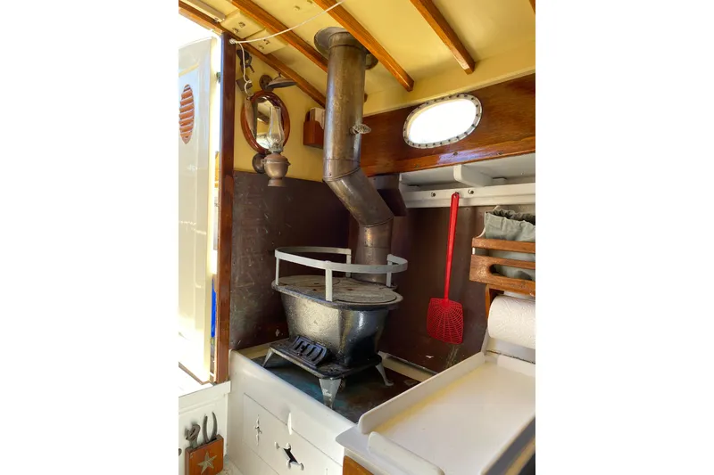 Slide: The Image of Interior of 1974 Herreshoff Rozinante sailboat with vintage stove and nautical decor. - 79