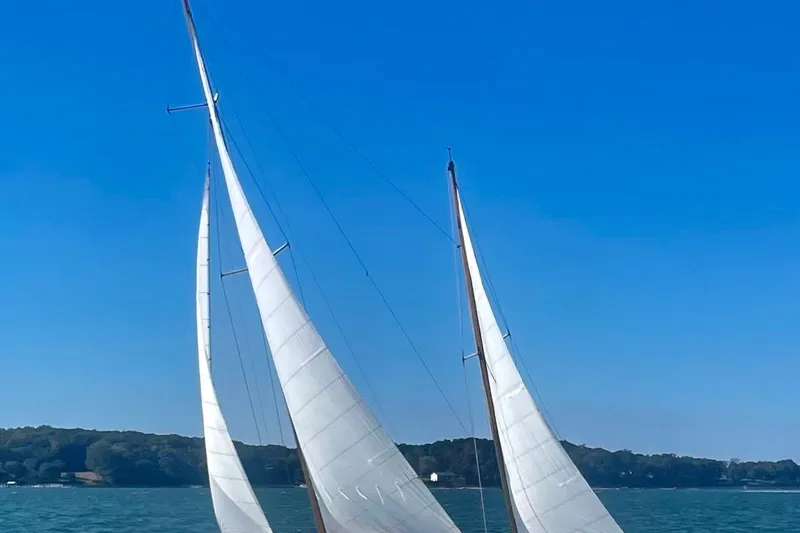 Slide: The Image of 1974 Herreshoff Rozinante sailboat with white sails on a clear blue day. - 3